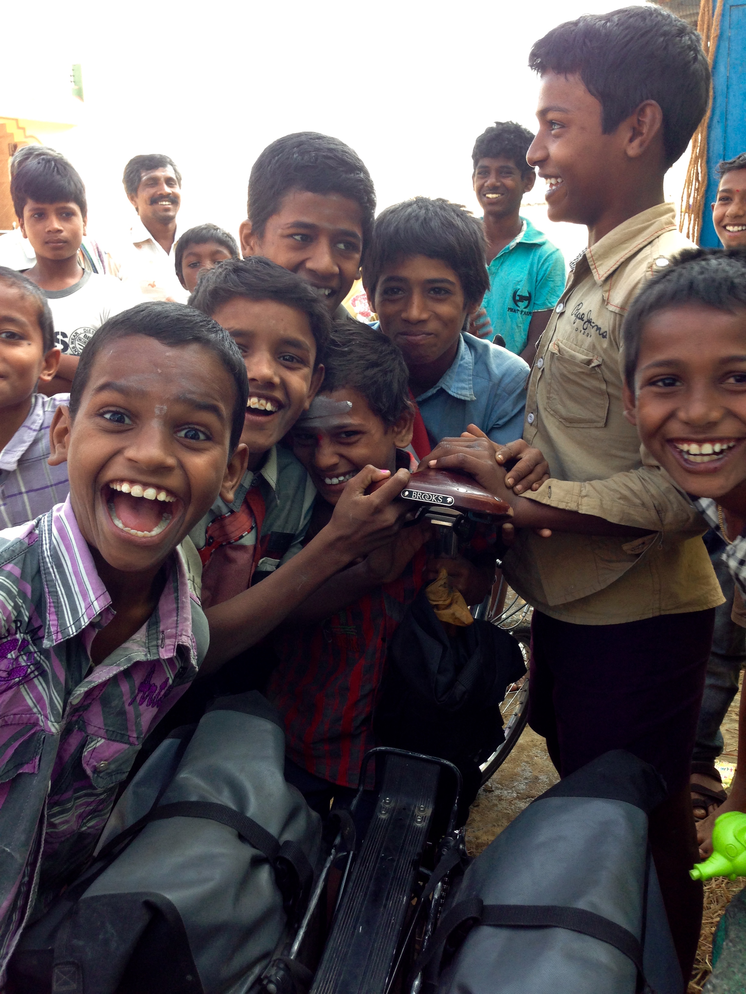 Children in an Indian village excited about a cyclist and his bike.